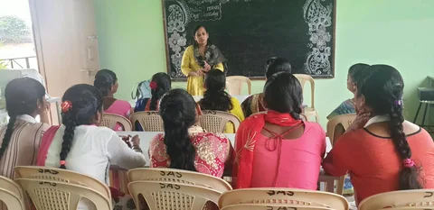 A speaker leading a discussion with women seated together in a classroom.