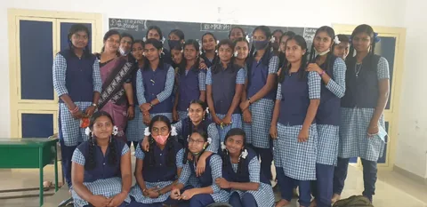 A group of students and an adult standing together in a classroom.